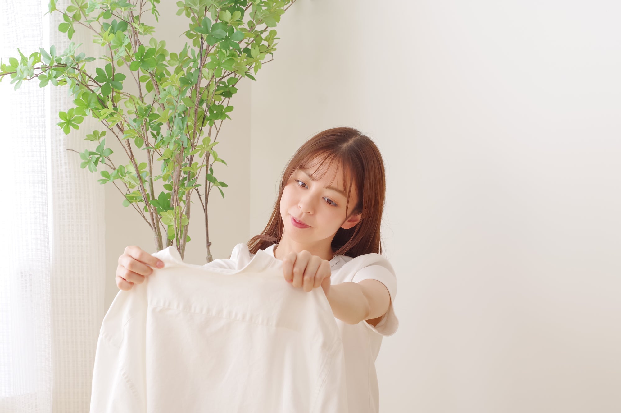 洗濯したシャツを見つめる女性